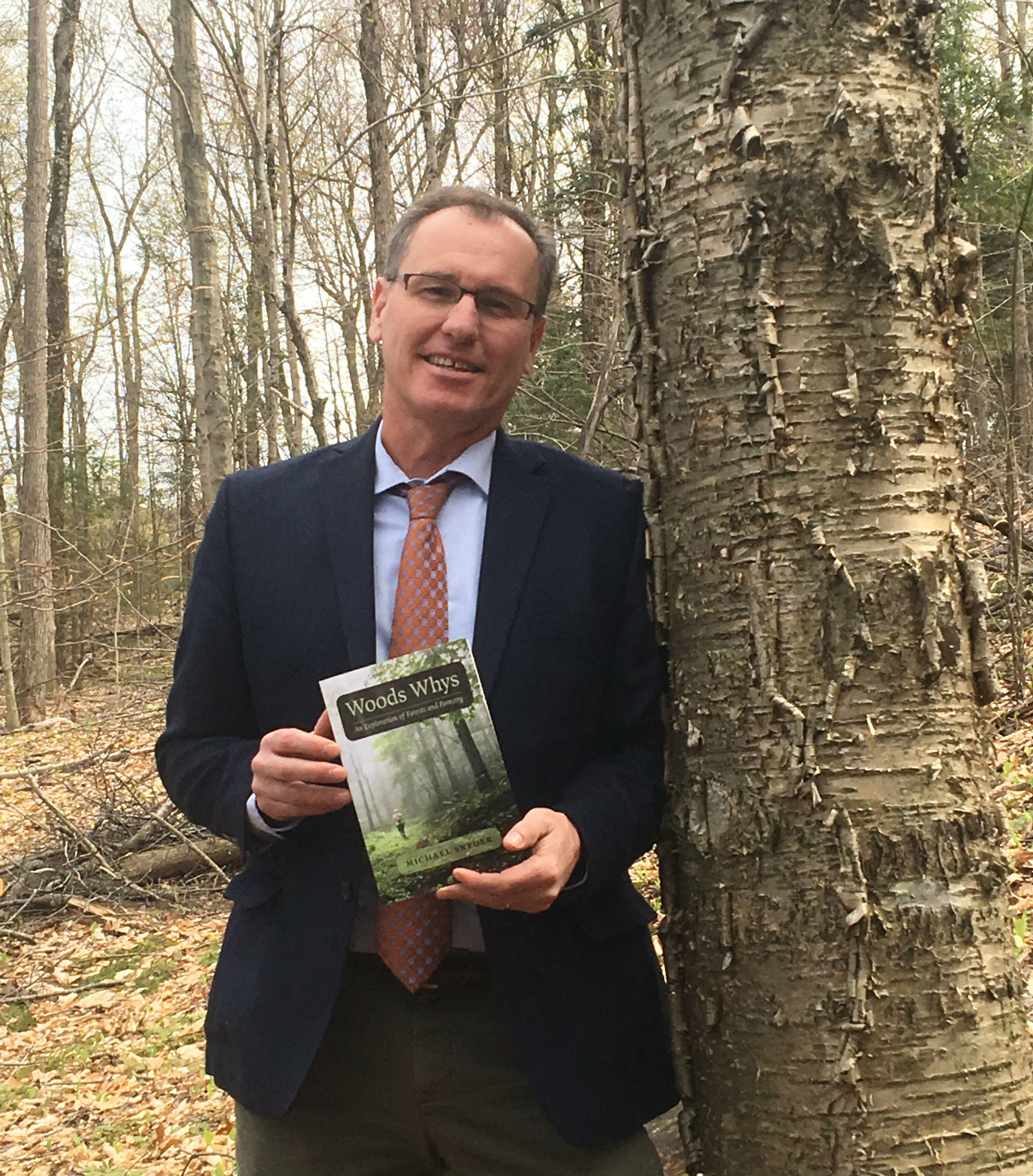 Commissioner michael snyder holding copy of Woods Whys